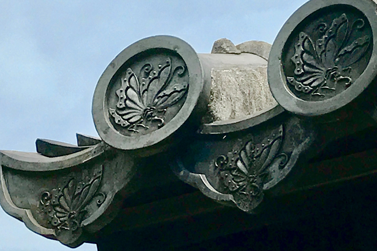 There is a swallowtail butterfly crest on the roof tile.