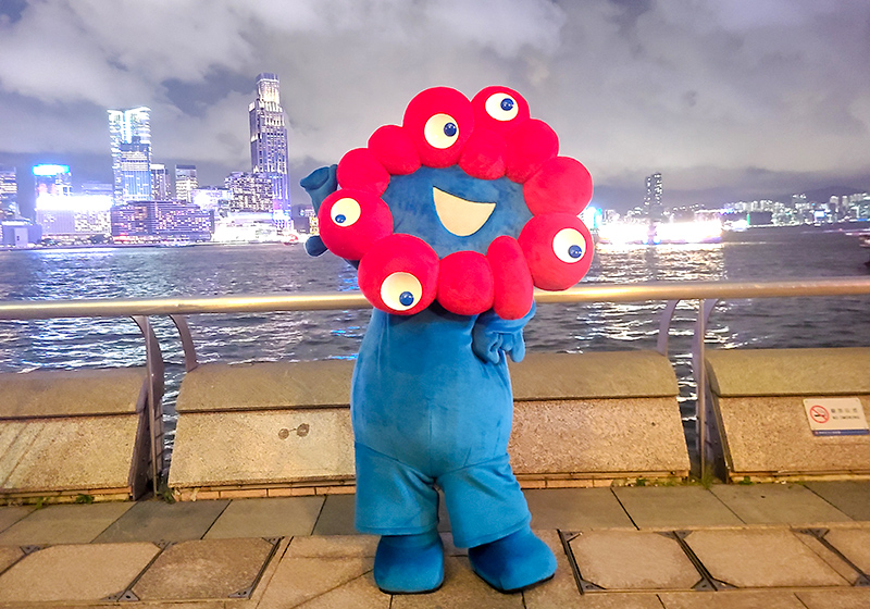 MYAKU-MYAKU posing for a photo with the night view of Hong Kong in the background