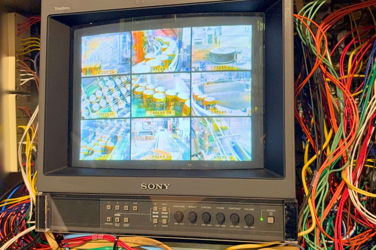 A monitor showing the beer-brewing process in a retro setting